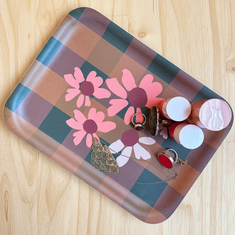Decorative tray with floral design on a wooden surface. Featuring drawings by Jillian Darnell.