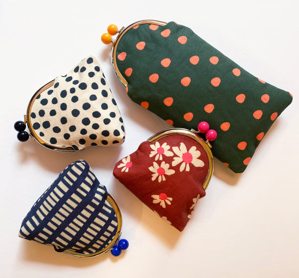 Four fabric coin purses with different patterns on a white background
