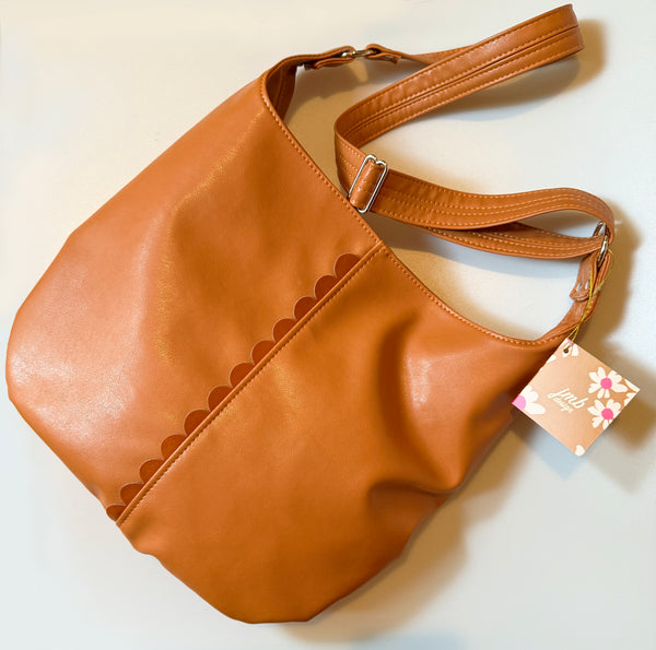 Mustard Cross Body Tote with a dark rust/orange colored scallop detail down the front of the bag. 